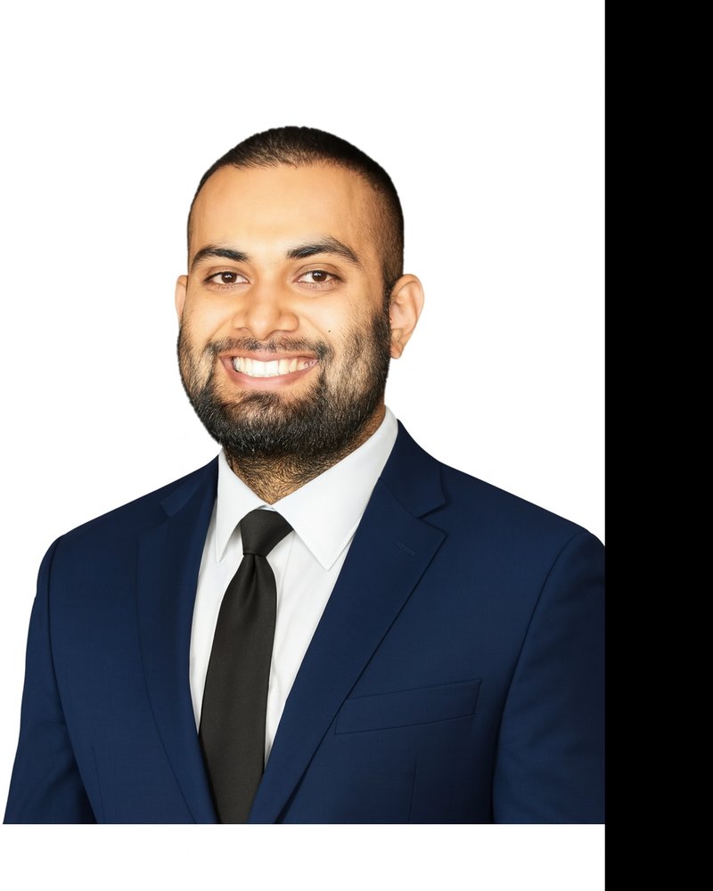 Zain Sardar, in a navy suit and black tie.